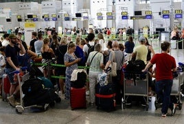 Turistas hacen cola ante el mostrador de facturación en el aeropuerto de Málaga.